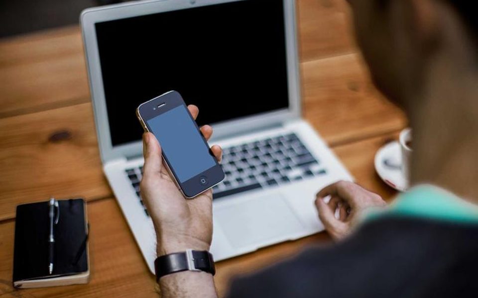 A phone lying on a wooden desk
